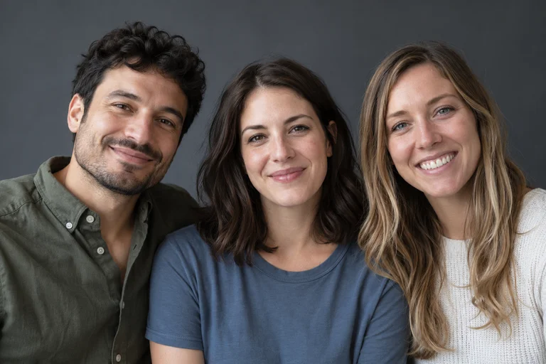 Three people posing together instead of a solo portrait.